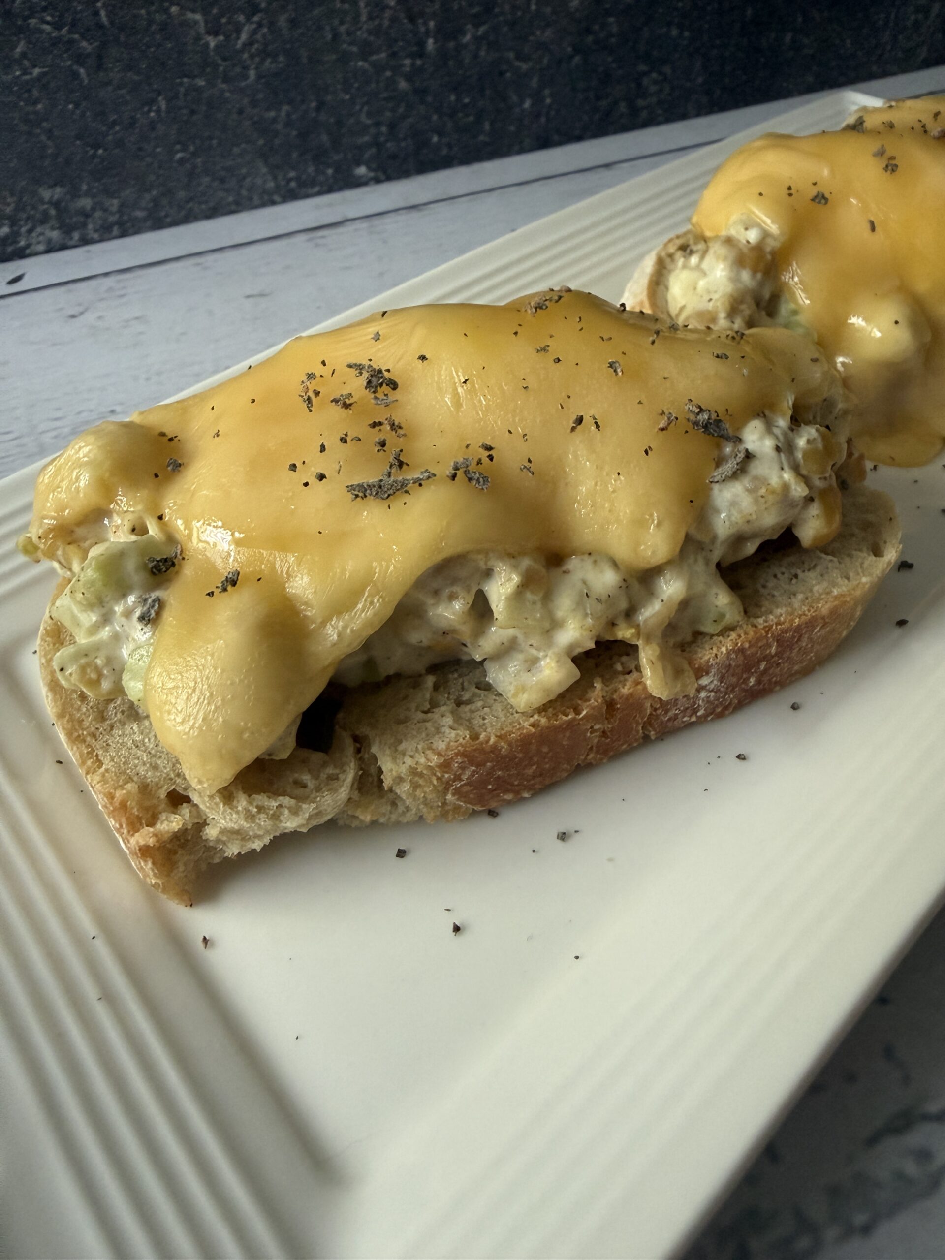 Sourdough toast topped with chickpea salad, topped with cheese.